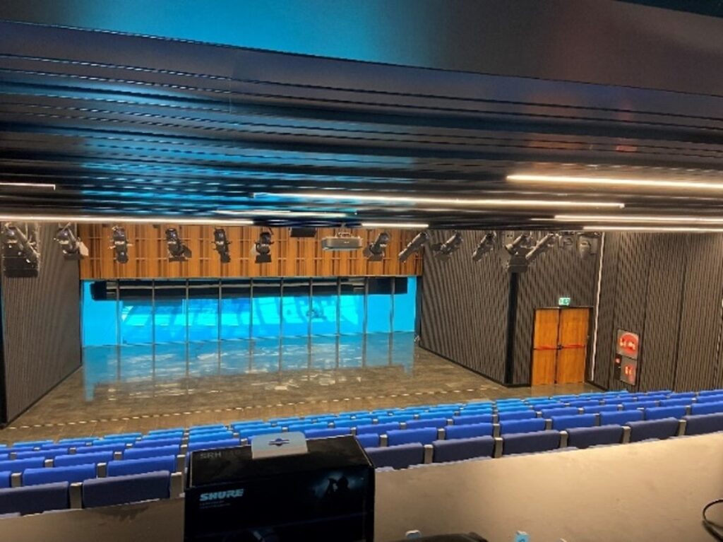 Auditorio moderno con iluminación azul y asientos organizados | Ingeniería acústica y diseño tecnológico en Tenerife